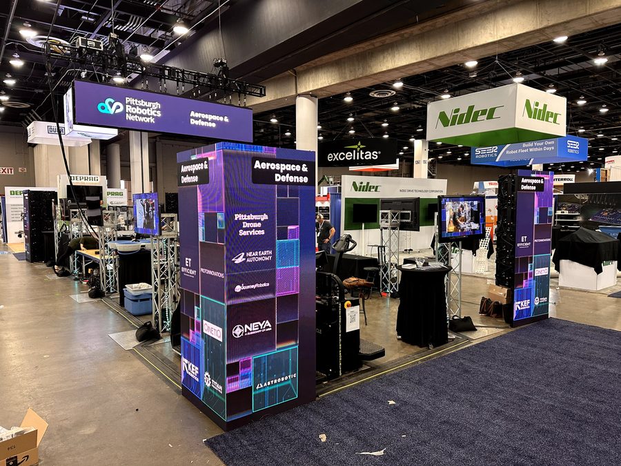 Aerospace and defense companies featured on the booth displays.