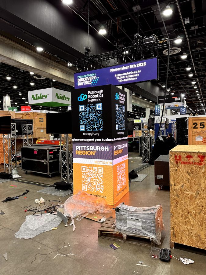 Pittsburgh Robotics Network corner display and Discovery Day overhead sign during setup.
